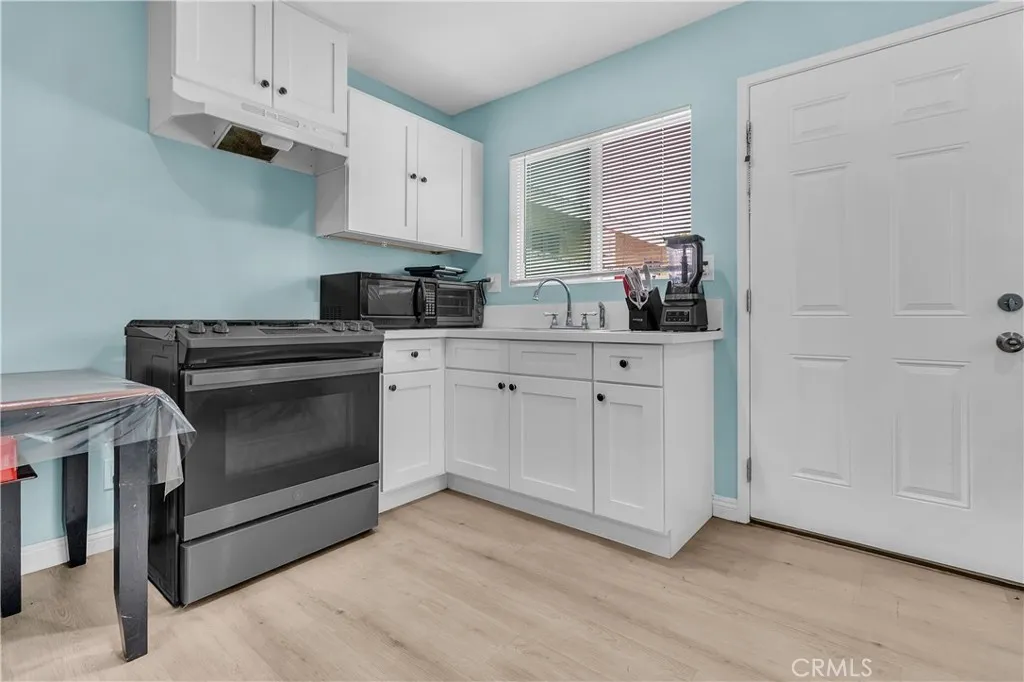 3738 Ahern Drive Baldwin Park, CA 91706 - Photo 22 of 36 a kitchen with white cabinets and white appliances