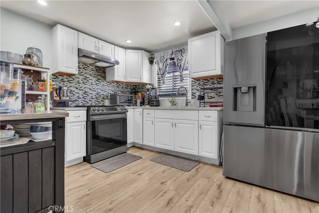 3738 Ahern Drive Baldwin Park, CA 91706 - Photo 6 of 36 a kitchen with white cabinets and appliances