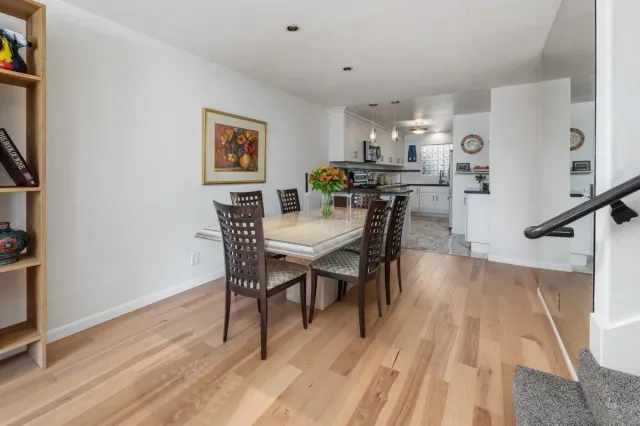 a dining room with furniture wooden floor a rug and a painting