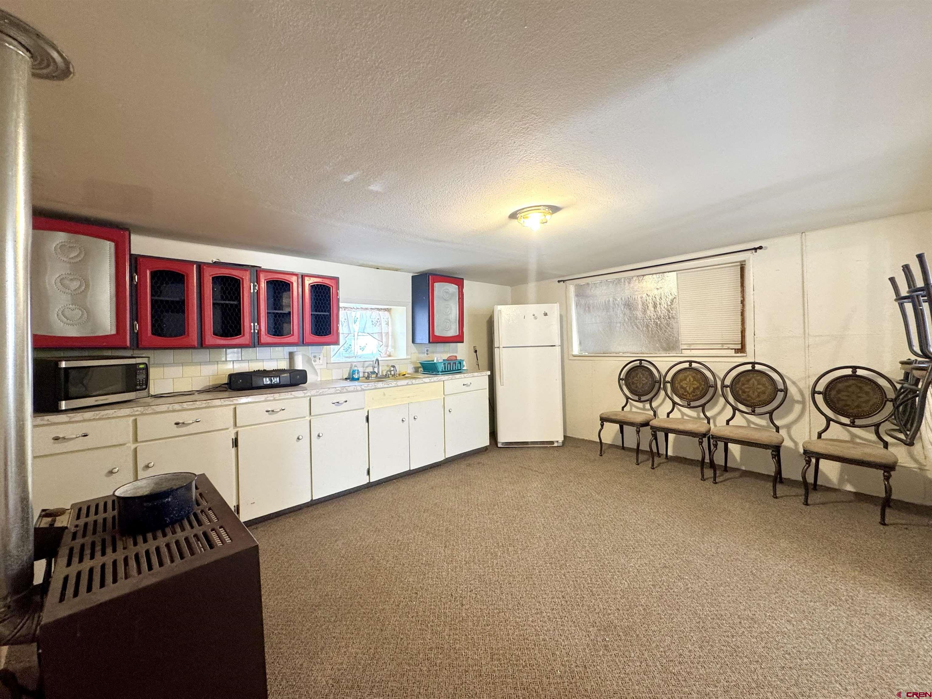 420 North 5th Street Manassa, CO 81141 - Photo 8 of 21 a kitchen with stainless steel appliances kitchen island granite countertop a stove and white cabinets