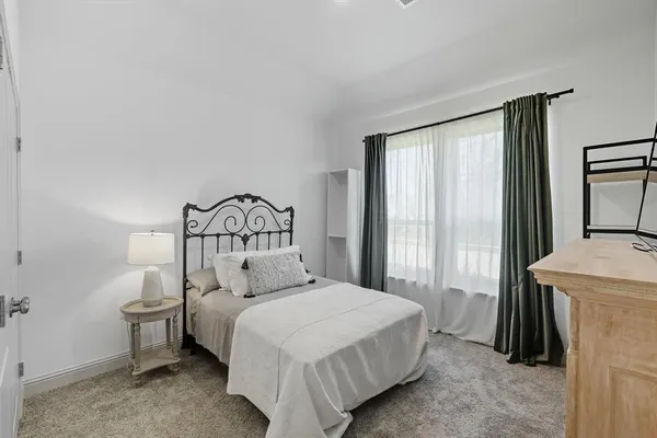 a bedroom with a bed and a large window