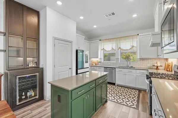 a kitchen with kitchen island granite countertop a sink stove and refrigerator