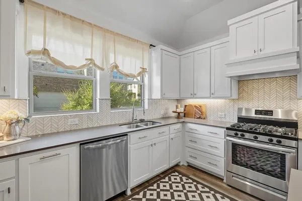 a kitchen with kitchen island granite countertop lots of counter top space and stainless steel appliances
