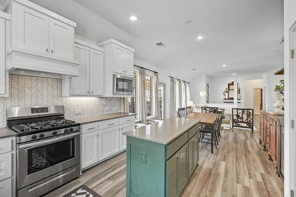 a dining hall with stainless steel appliances refrigerator dining table and chairs