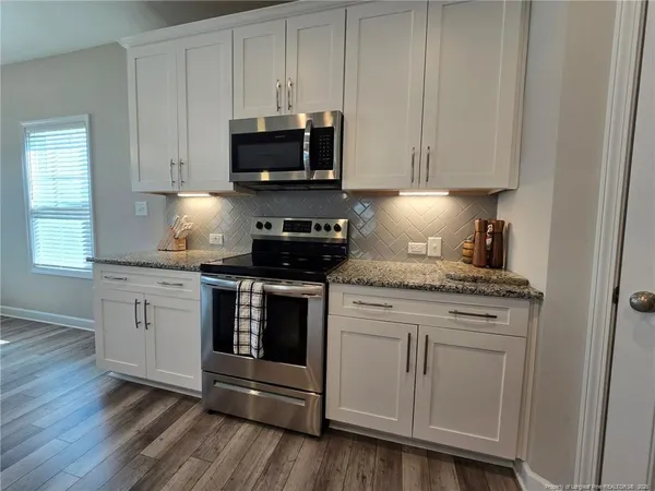 a kitchen with stainless steel appliances granite countertop a stove a microwave and cabinets
