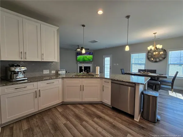 a kitchen with stainless steel appliances granite countertop a sink a stove and a wooden floors