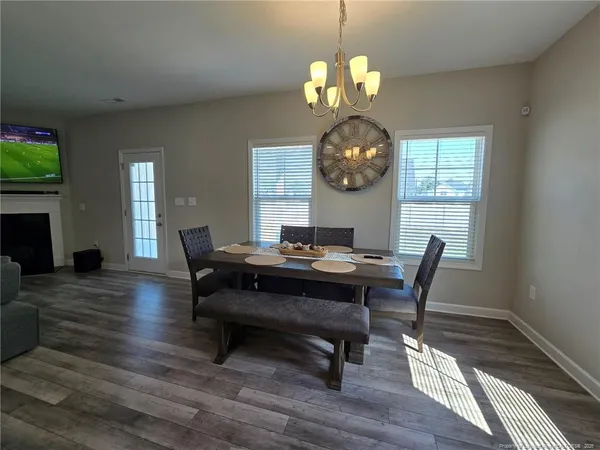 a view of a dining room with furniture a chandelier and wooden floor