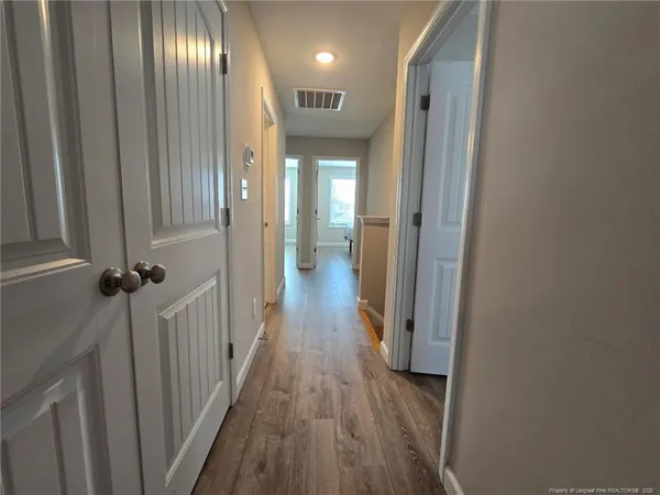 a view of a hallway with wooden floor