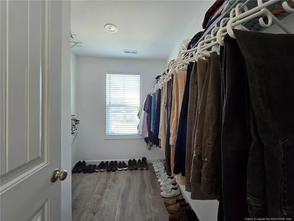 a view of walk in closet with clothes and shoes
