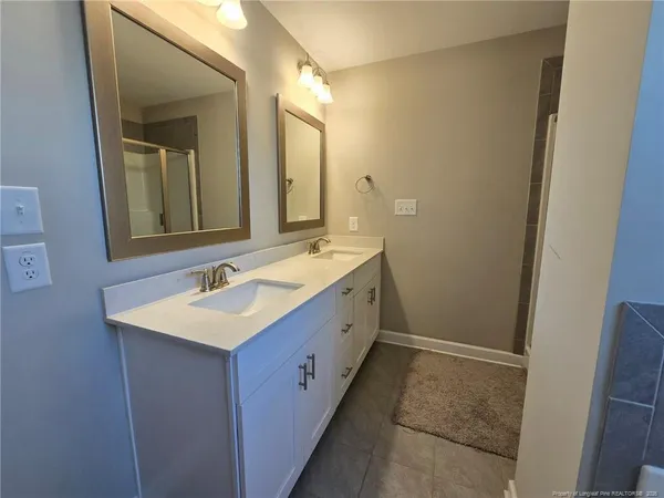 a spacious bathroom with a double vanity sink and a mirror
