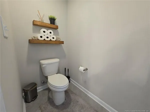 a white toilet sitting next to a small small stove