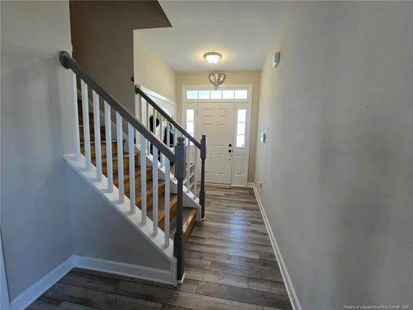 a view of staircase with wooden floor and white walls