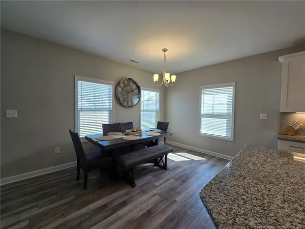 a living room with a table chairs and a window
