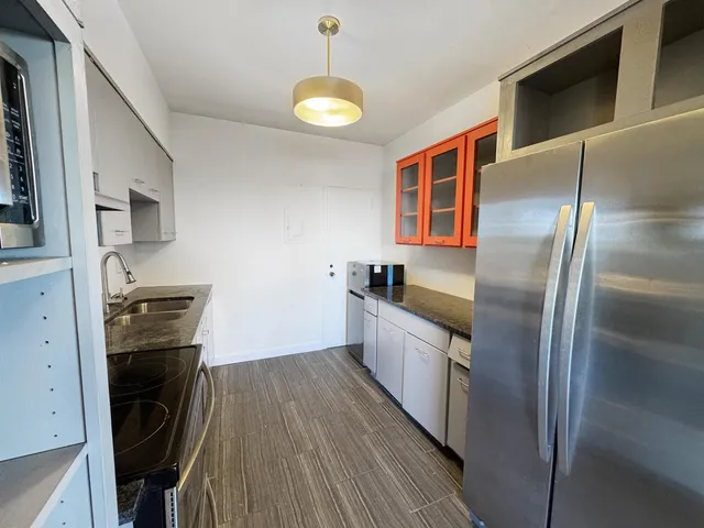 a kitchen with stainless steel appliances granite countertop a stove a sink and a refrigerator