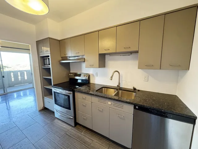 a kitchen with stainless steel appliances granite countertop a sink stove and cabinets