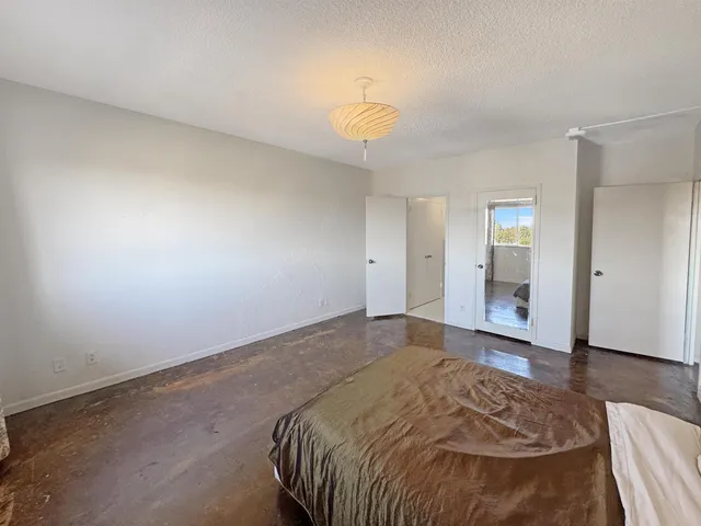 a spacious bedroom with a bed and a chandelier