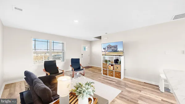 a living room with furniture a wooden floor and a flat screen tv