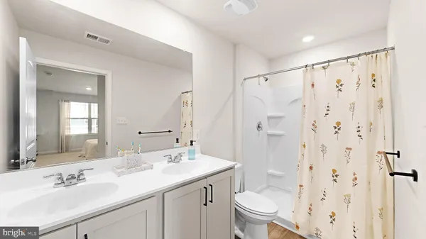 a bathroom with a double vanity sink toilet and shower