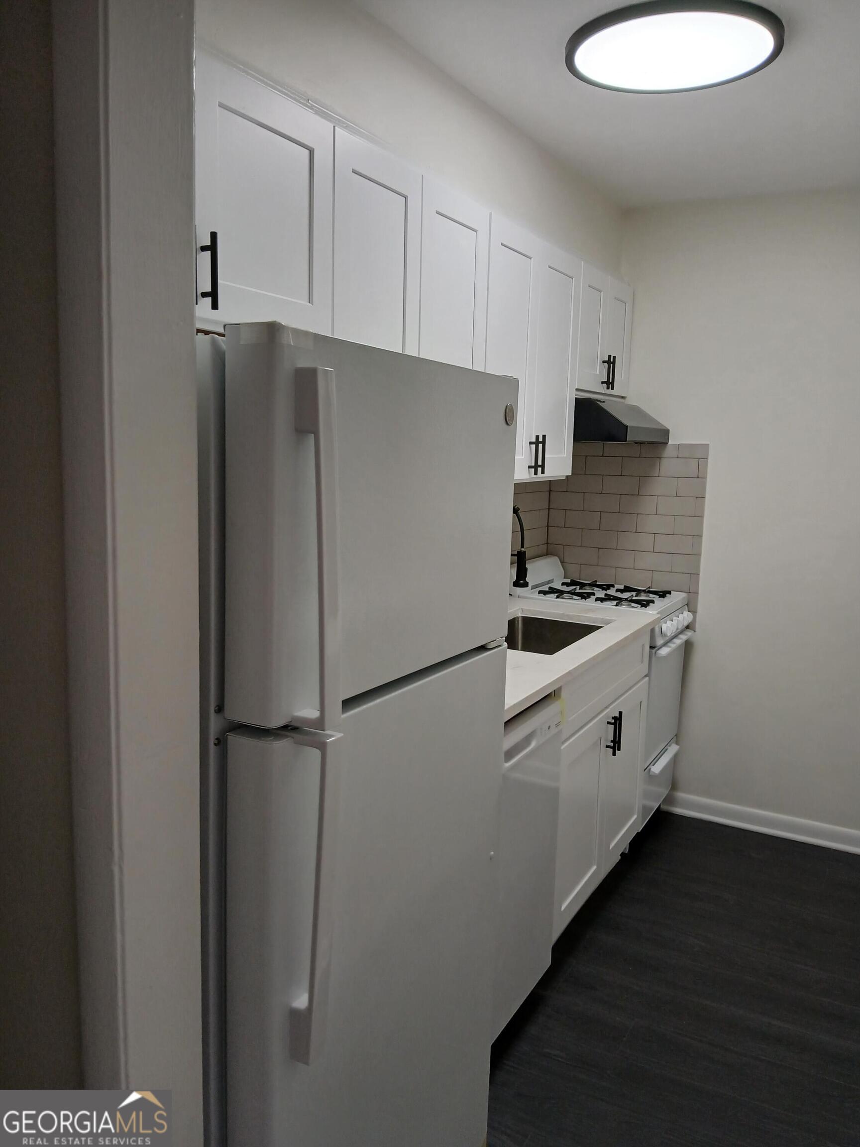 2805 Northeast Expressway Northeast, Unit B18 Atlanta, GA 30345 - Photo 4 of 13 a white refrigerator freezer and a stove sitting inside of a kitchen