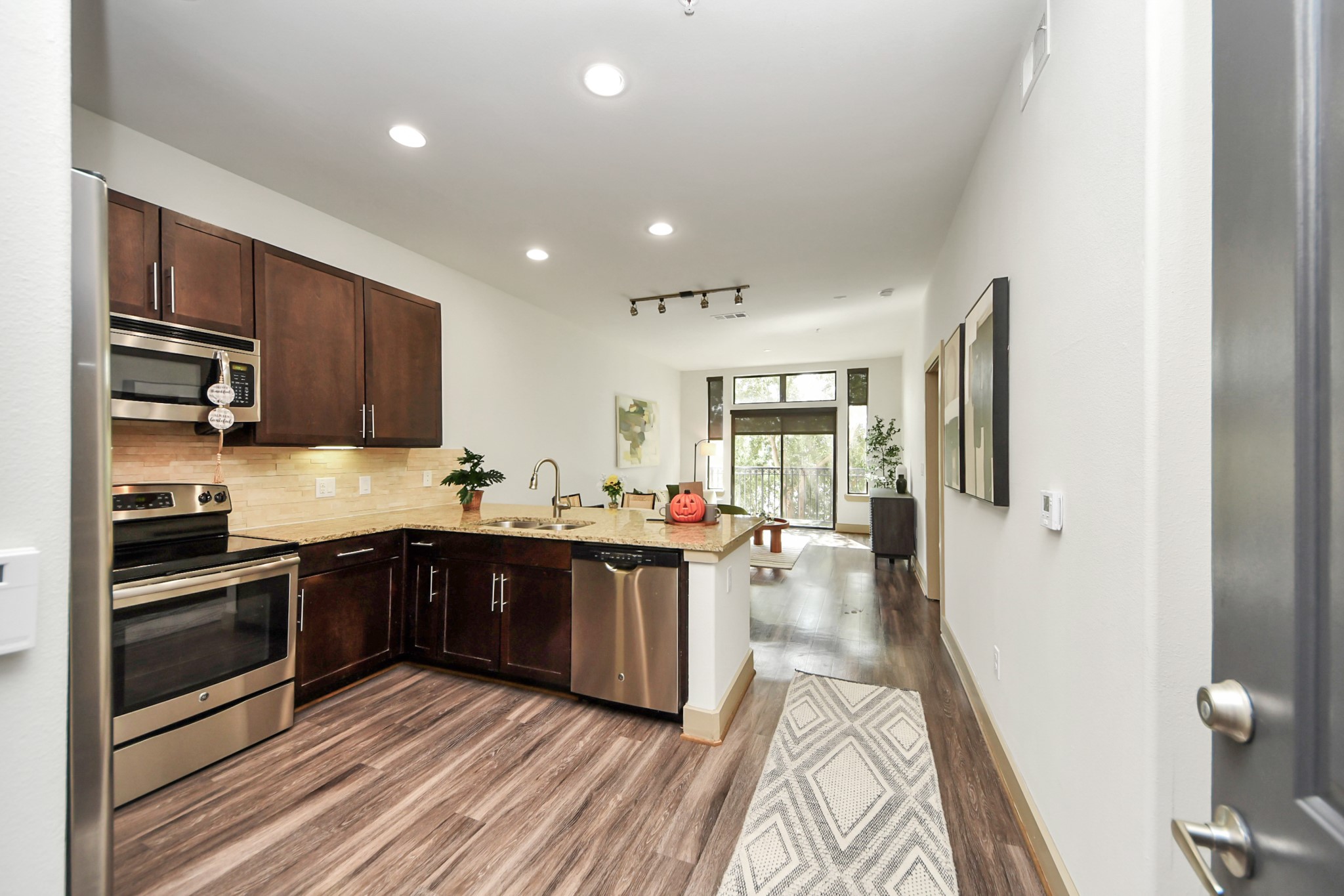 3800 Main Street, Unit 1 226 Houston, TX 77002 - Photo 21 of 50 a kitchen with stainless steel appliances granite countertop wooden cabinets a stove top oven a sink and dishwasher