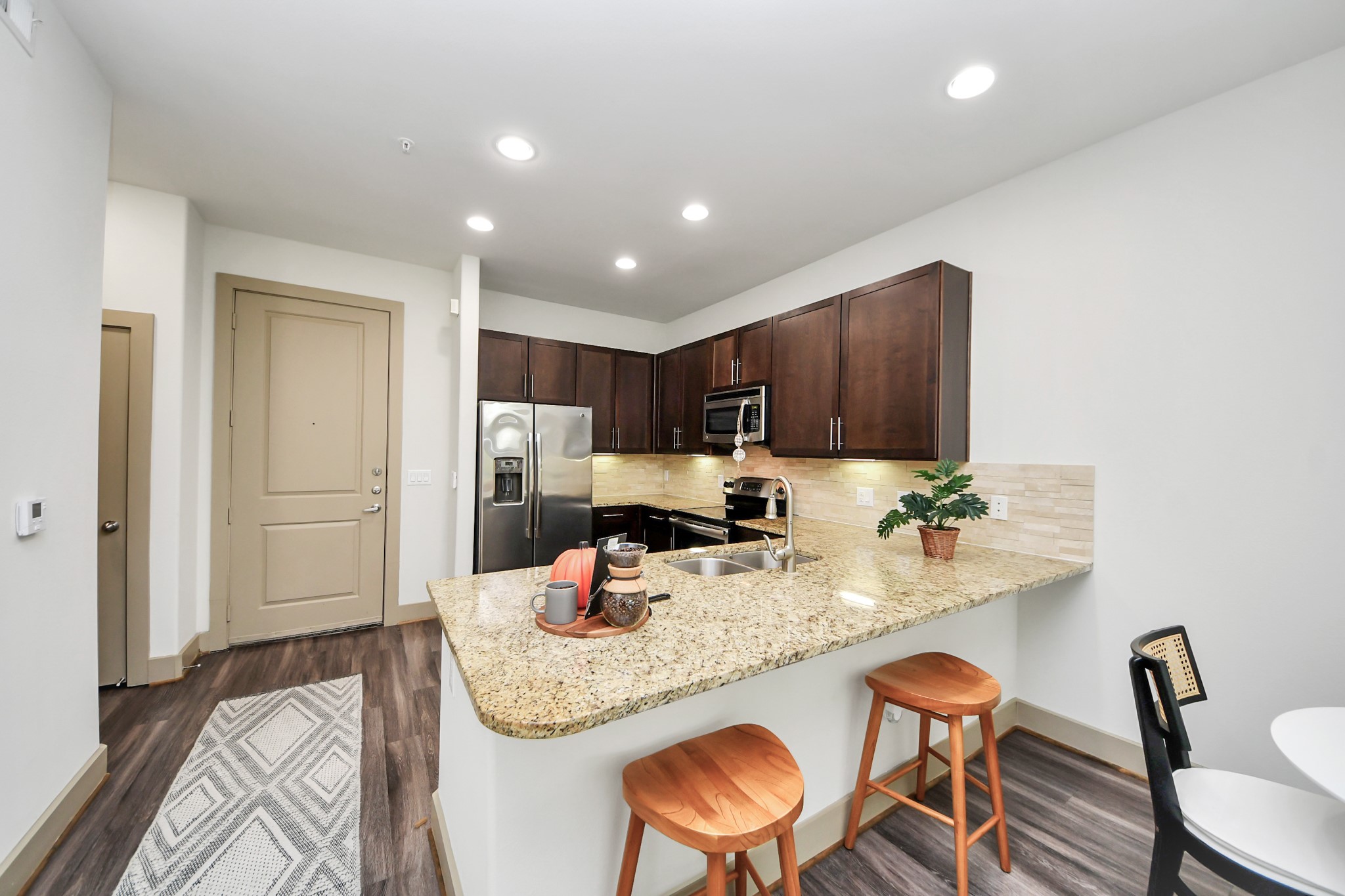 3800 Main Street, Unit 1 226 Houston, TX 77002 - Photo 26 of 50 a kitchen with granite countertop kitchen island stainless steel appliances sink refrigerator dining table and chairs