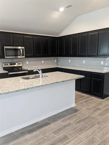 a kitchen with granite countertop a sink and a window