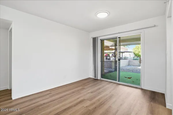 an empty room with wooden floor and windows