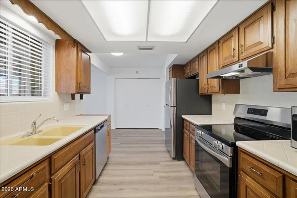a kitchen with a sink stove and cabinets