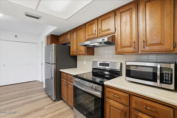 a kitchen with stainless steel appliances granite countertop a stove a refrigerator and a microwave