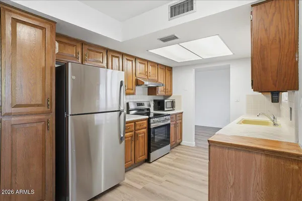a kitchen with stainless steel appliances a refrigerator stove and sink