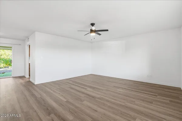 a view of a room with wooden floor and a ceiling fan