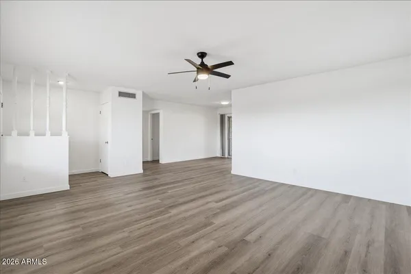 an empty room with wooden floor and windows