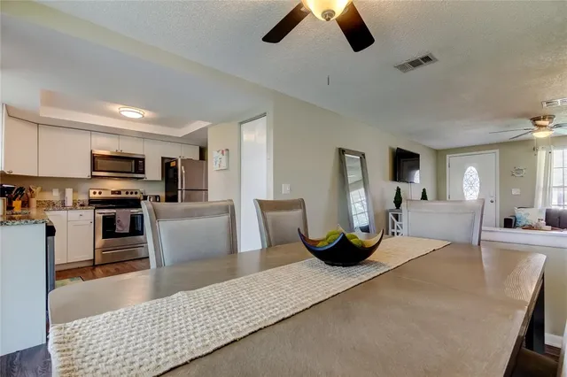 a living room with stainless steel appliances furniture and a kitchen view