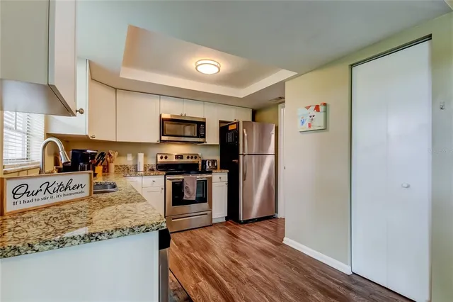 a kitchen with granite countertop a refrigerator and a sink