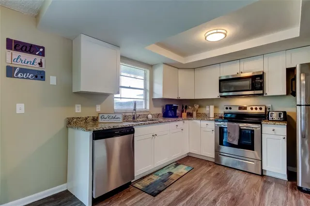 a kitchen with granite countertop a stove top oven and sink