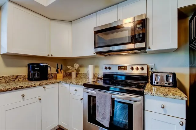 a kitchen with stainless steel appliances granite countertop a sink stove and microwave