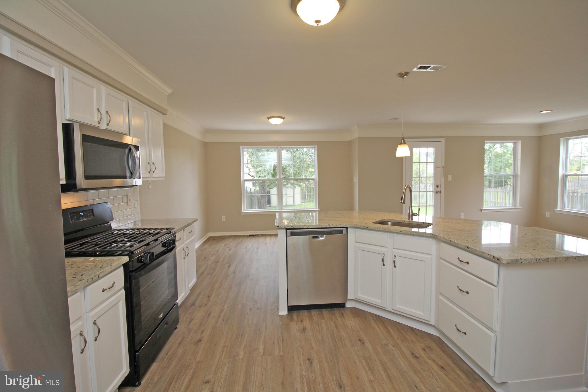 121 Wilson Lane Berlin, NJ 08009 - Photo 18 of 59 a kitchen with granite countertop a stove top oven a sink a counter space and cabinets