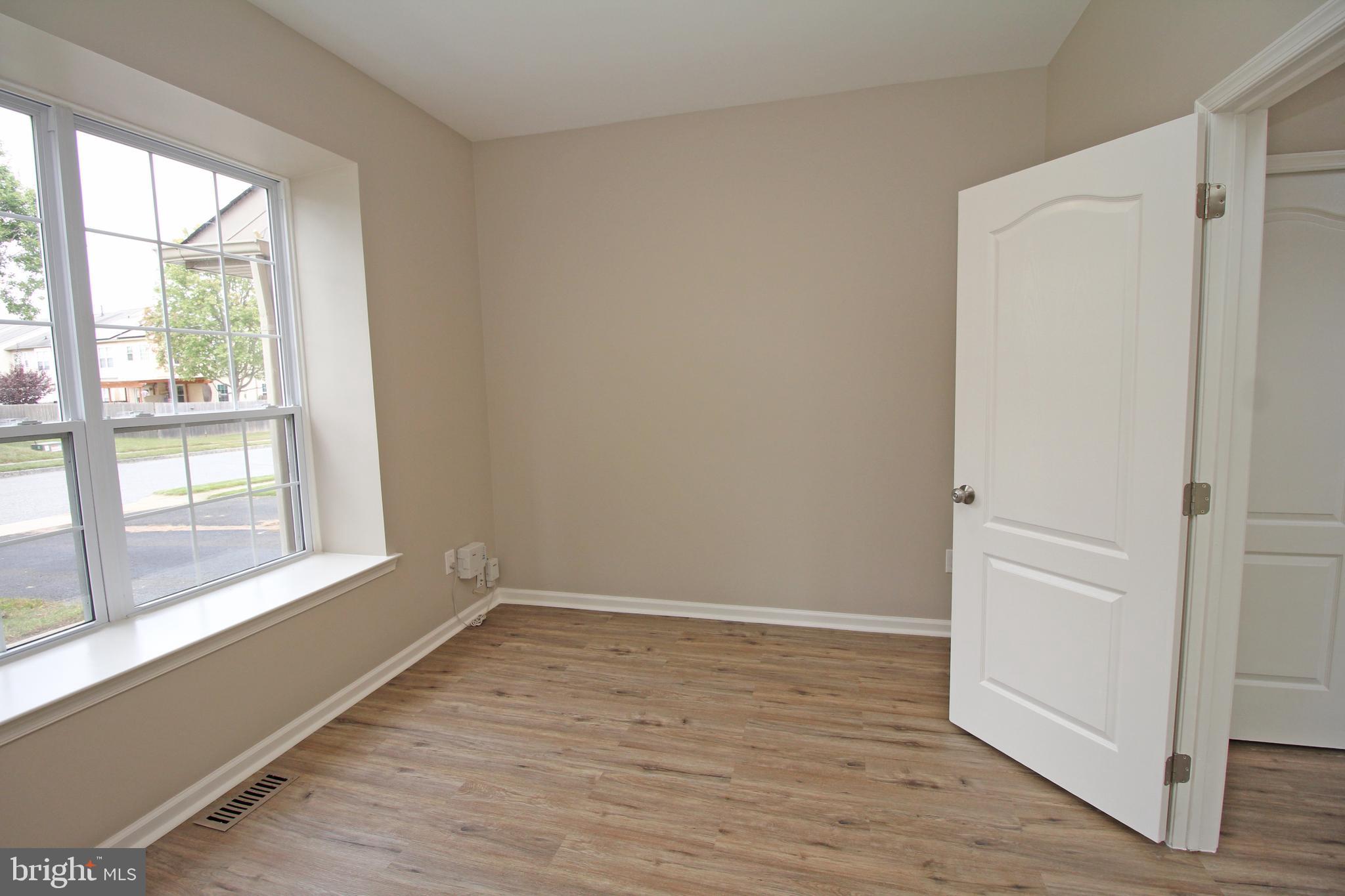 121 Wilson Lane Berlin, NJ 08009 - Photo 6 of 59 a view of an empty room with wooden floor and a window