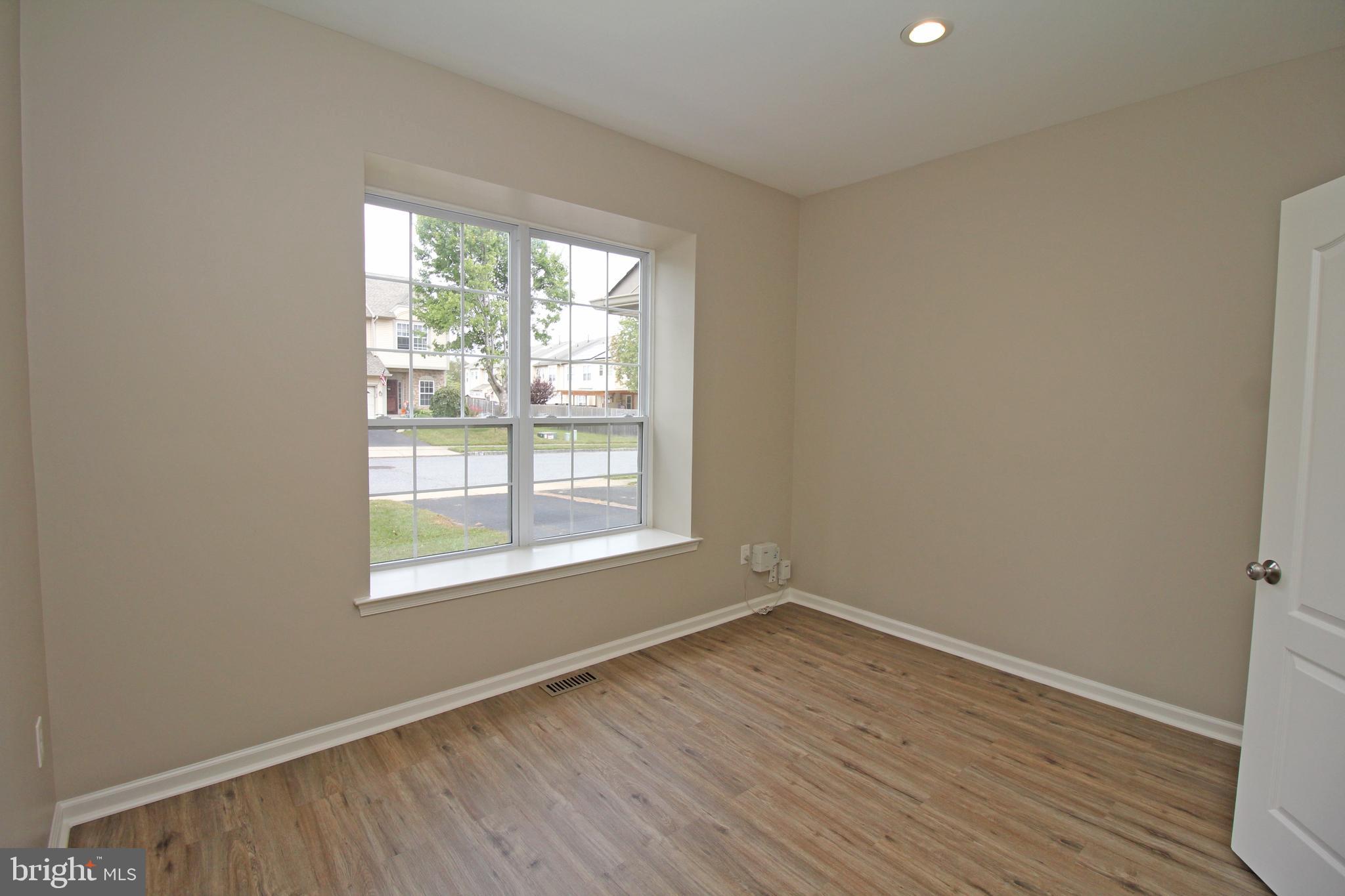 121 Wilson Lane Berlin, NJ 08009 - Photo 7 of 59 an empty room with wooden floor and windows