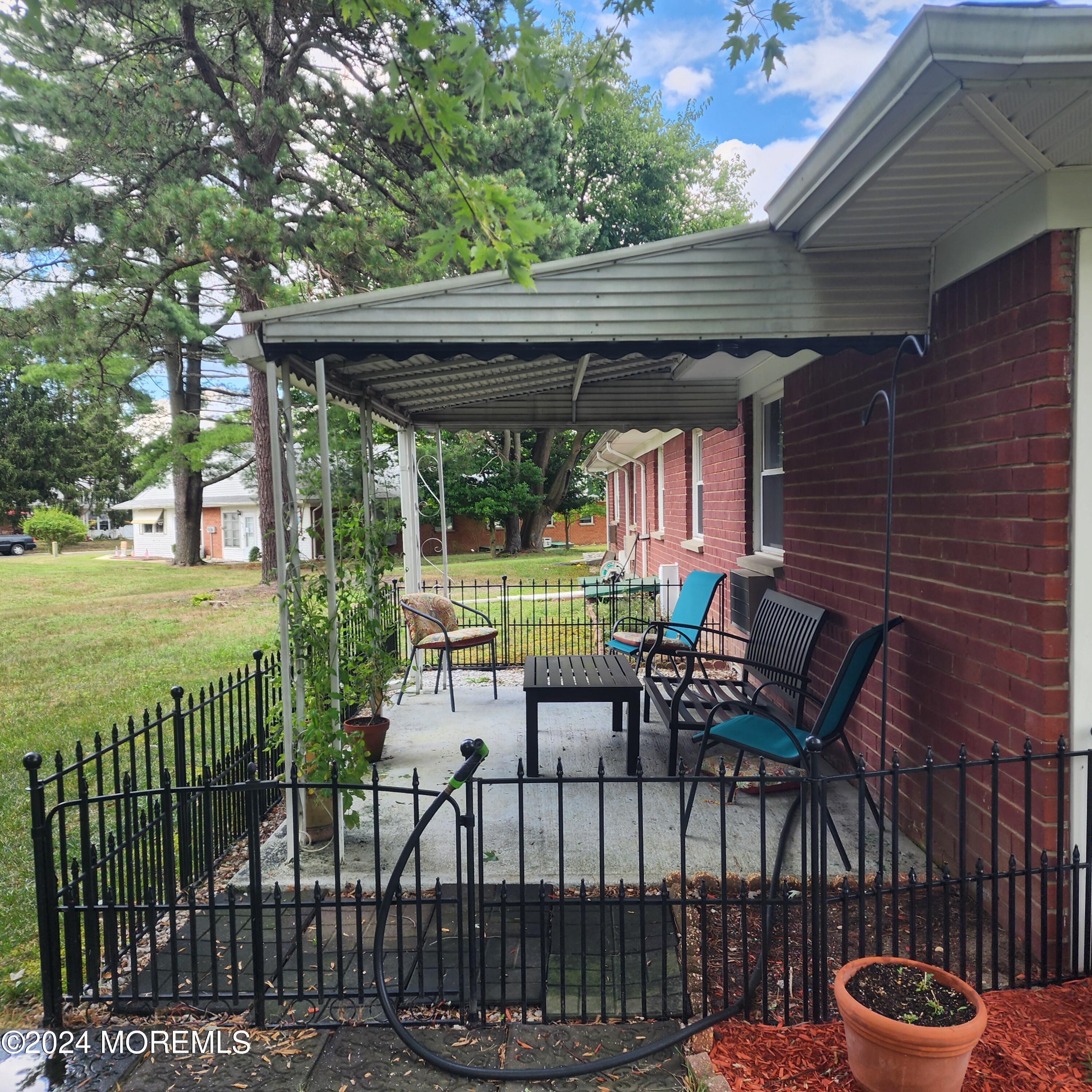 108 Hope Road, Unit D Whiting, NJ 08759 - Photo 4 of 26 a view of a patio with a table chairs and a backyard