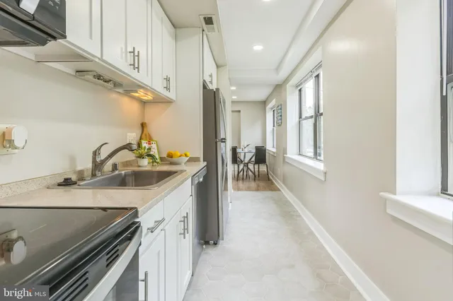 a kitchen with stainless steel appliances granite countertop a sink a stove and a next to a window