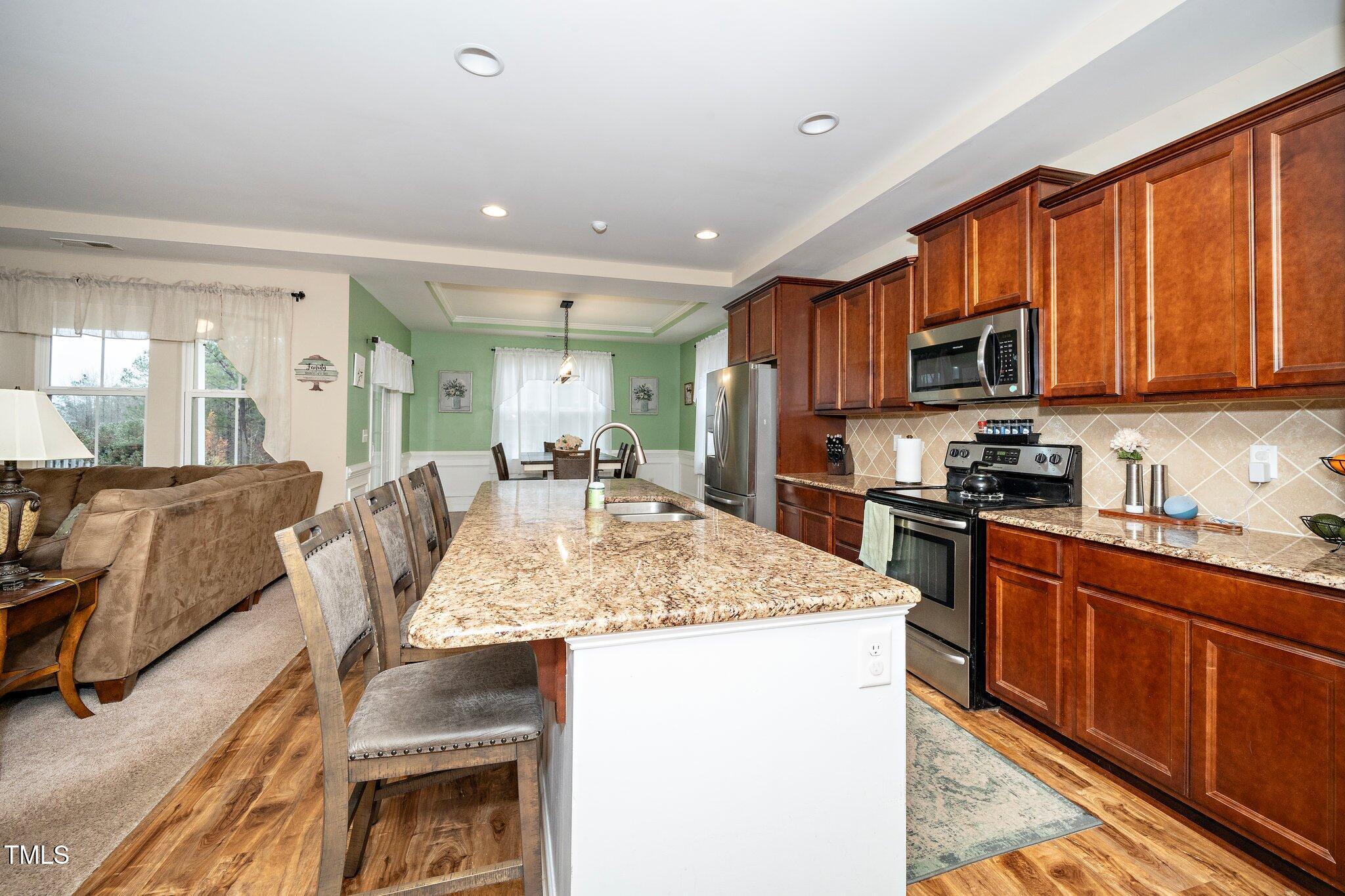 82 Mariners Point Way Garner, NC 27529 - Photo 13 of 30 a kitchen with stainless steel appliances granite countertop a sink stove and refrigerator