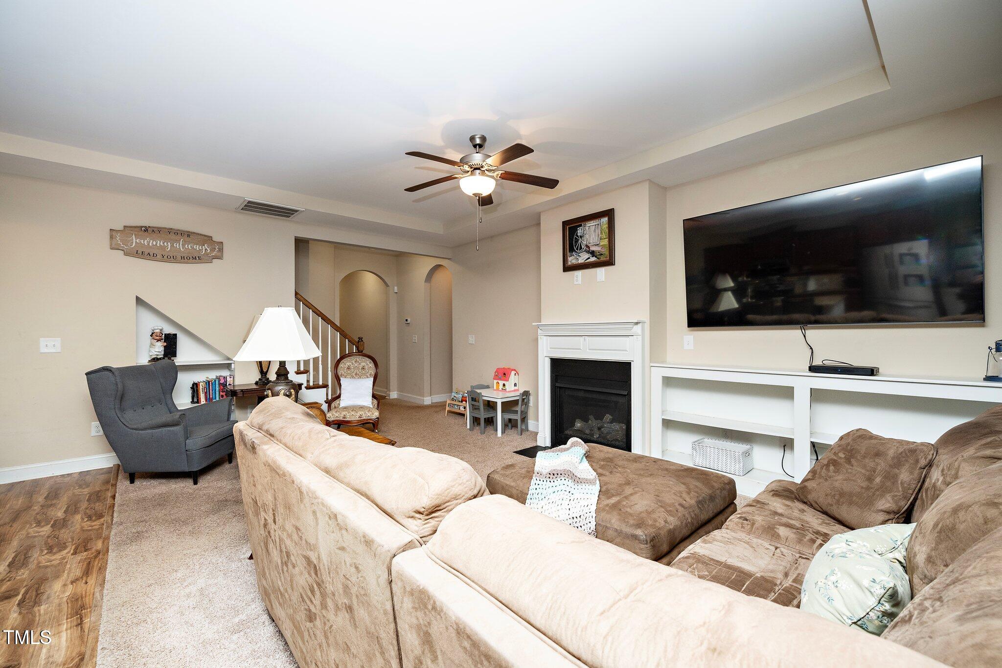 82 Mariners Point Way Garner, NC 27529 - Photo 9 of 30 a living room with furniture a fireplace and a flat screen tv
