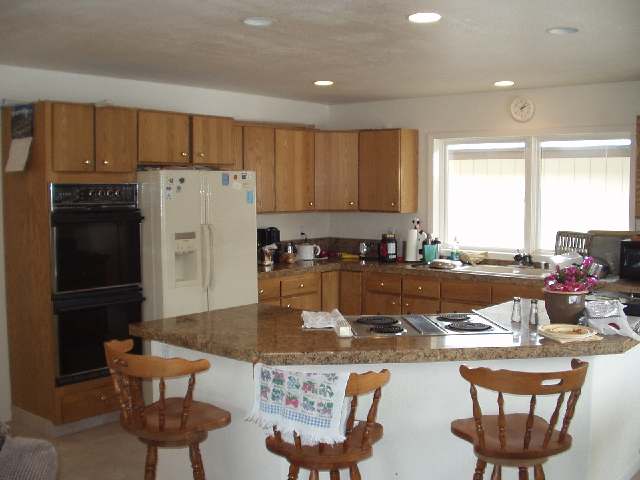 13015 Welcome Reno, NV 89511 - Photo 3 of 8 a kitchen with stainless steel appliances granite countertop a refrigerator a stove and a dining table with wooden cabinet