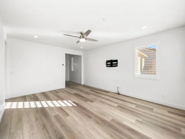 a view of a big room with wooden floor and windows