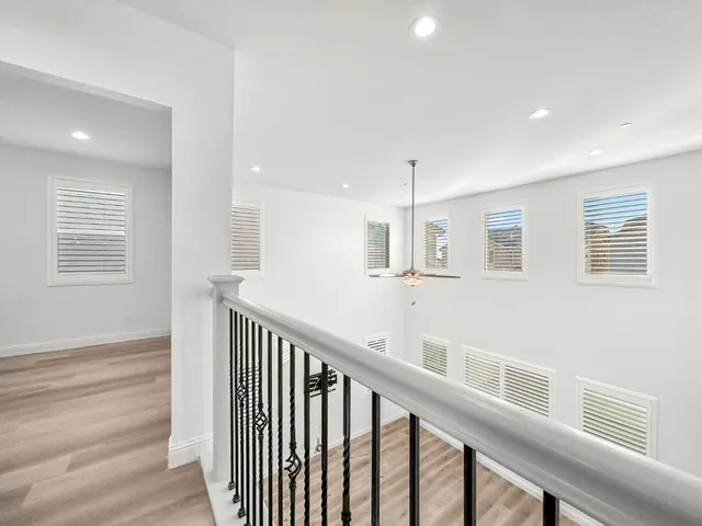 a view of a hallway with wooden floor and staircase