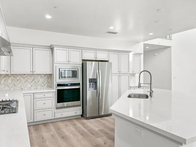 a kitchen with kitchen island a sink stainless steel appliances and cabinets