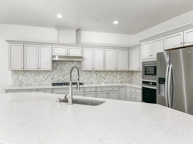 a kitchen with stainless steel appliances a refrigerator stove and cabinets