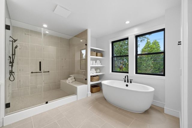 a spacious bathroom with a double vanity sink a mirror a bathtub and shower