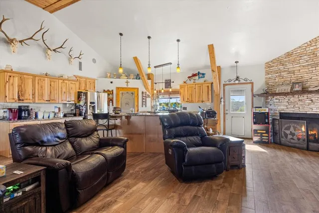 a kitchen with stainless steel appliances a dining table chairs sink and wooden floor